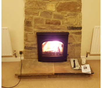 Di Lusso R5 Woodburner - with curved sides in black fitted by our installers with thermally insulated twin wall chimney system near Horsham, West Sussex.